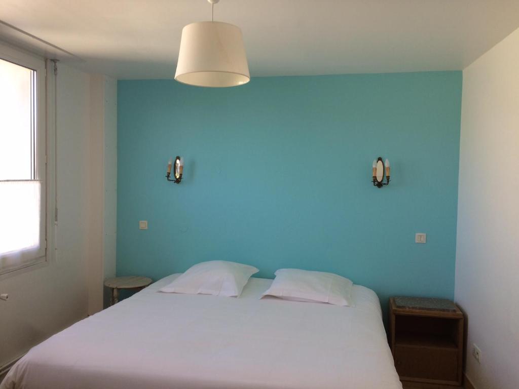 - une chambre avec un lit blanc et un mur bleu dans l'établissement Hotel Particulier Richelieu, à Calais