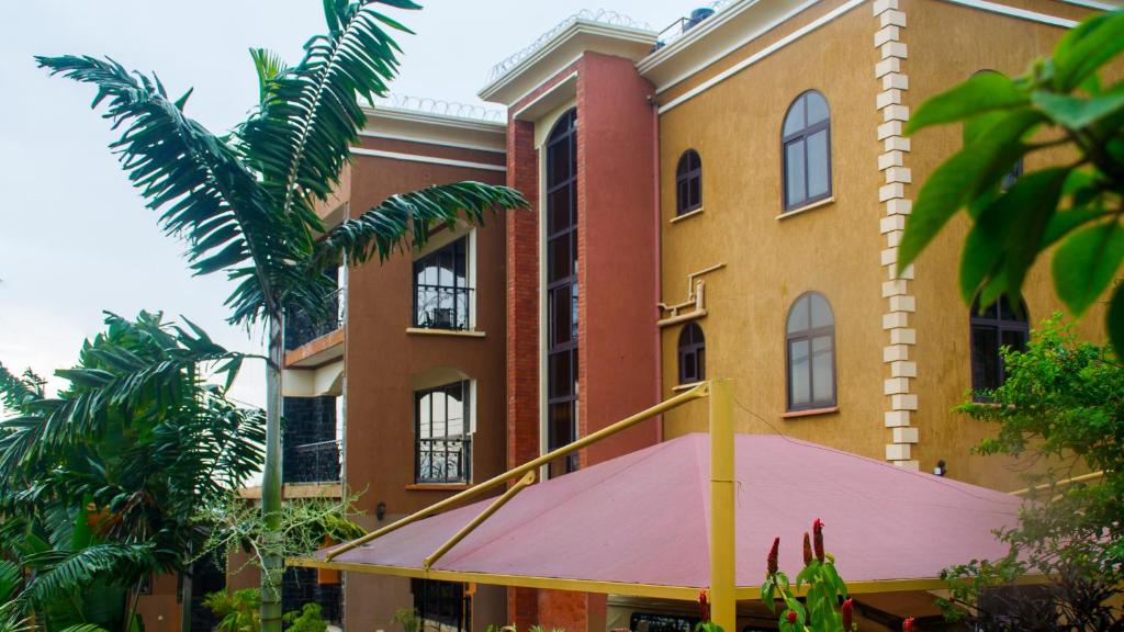 un edificio con un toldo rosa delante de él en Bona Safari Villa Bunamwaya en Kampala