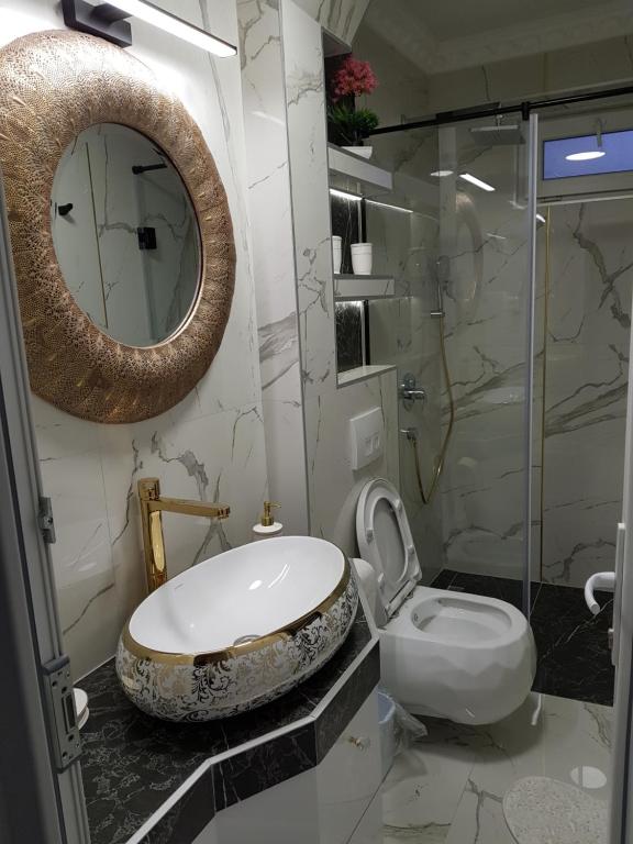 y baño con aseo, lavabo y espejo. en Apartment Jenny in Sarajevo City Center, en Sarajevo