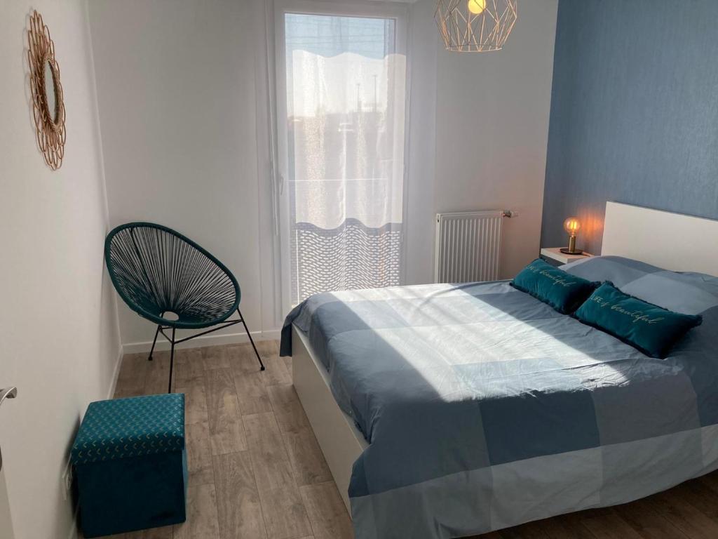 a bedroom with a bed and a chair and a window at F3 standing in Les Ulis
