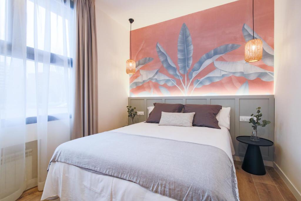1 dormitorio con 1 cama y una gran pintura en la pared en Home42, en Madrid