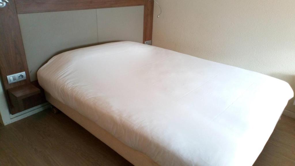 een groot wit bed in een kleine kamer bij Kyriad Direct Metz Nord – Woippy in Woippy