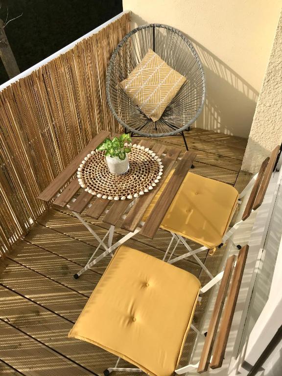 un patio avec une table et des chaises sur un balcon dans l'établissement Cabourg - Bel appartement lumineux avec balcon dans résidence privée, à Cabourg