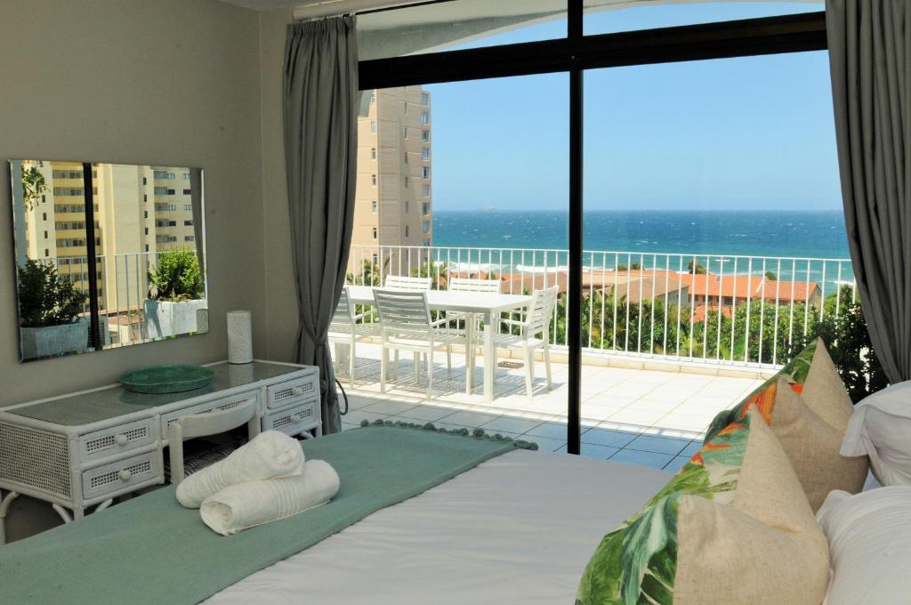 1 dormitorio con cama y vistas a un balcón en 20 Marine Terraces, en Durban