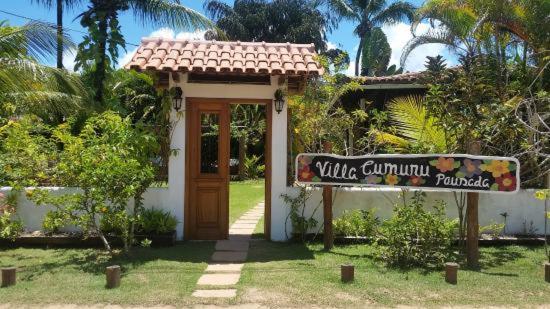 een klein huis met een bord ervoor bij Pousada Villa Cumuru in Cumuruxatiba
