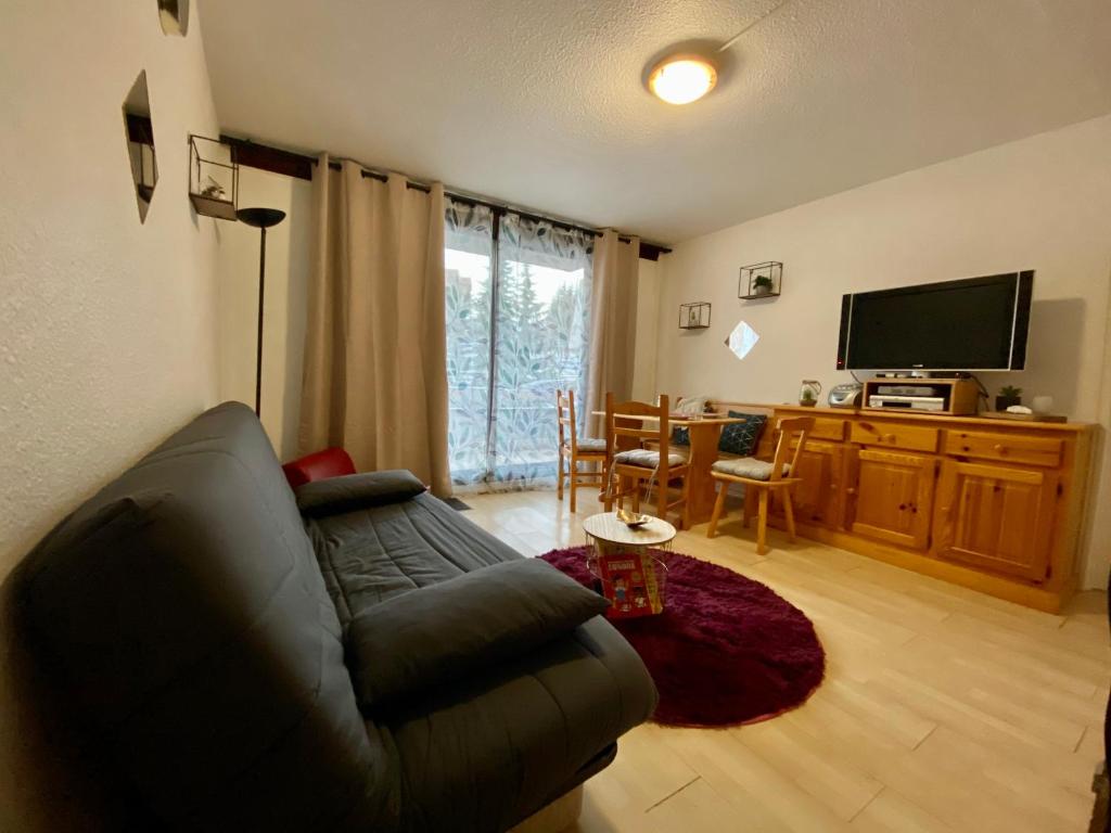 un salon avec un canapé et une télévision dans l'établissement Au pied des pistes (Le Corbier/73), à Villarembert