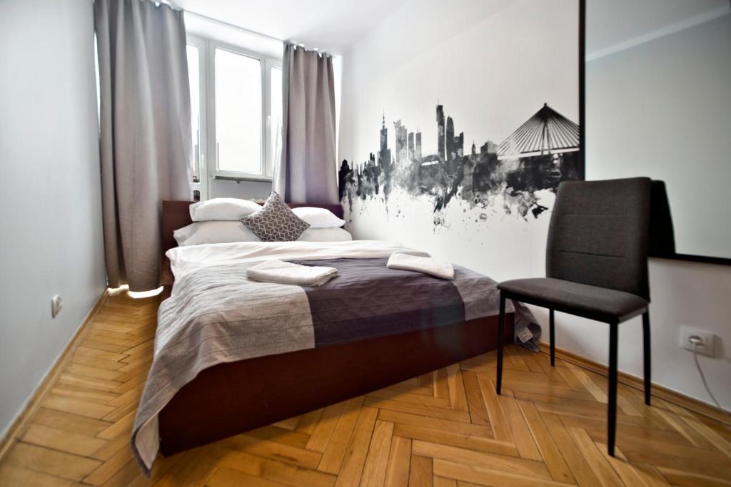 ワルシャワにあるHala Mirowska Apartmentsのベッドルーム1室(ベッド1台、椅子付)