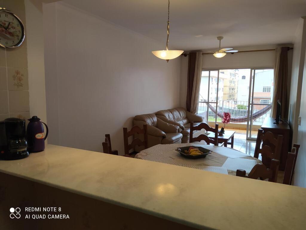 een keuken en een woonkamer met een tafel en stoelen bij Aconchegante e Amplo Apartamento Familiar pertinho da Praia! in Guarujá