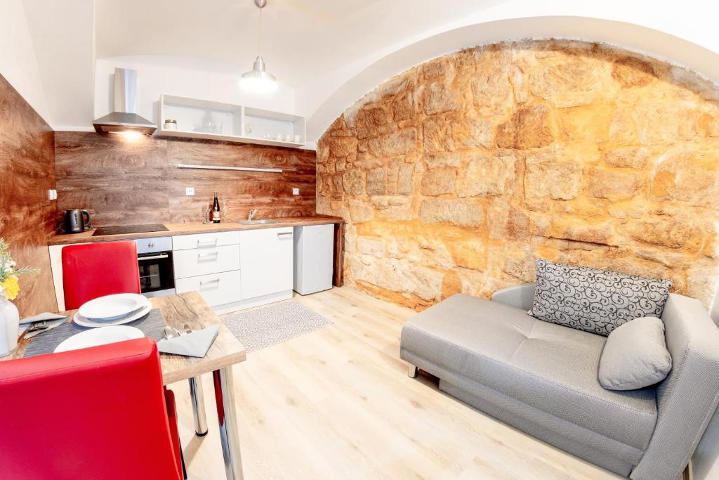 a living room with a couch and a stone wall at Pilsen apartment in Plzeň