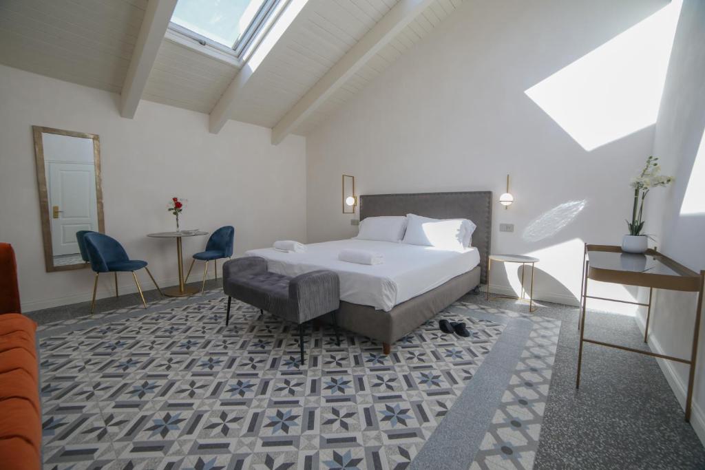 a bedroom with a bed and a table and chairs at 20 Miglia Boutique Hotel in Catania