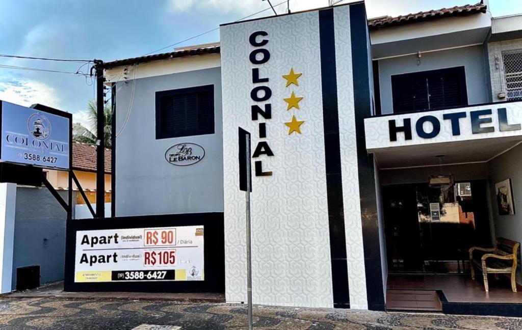 a hotel with a sign in front of it at Hotel Colonial in Pôrto Ferreira