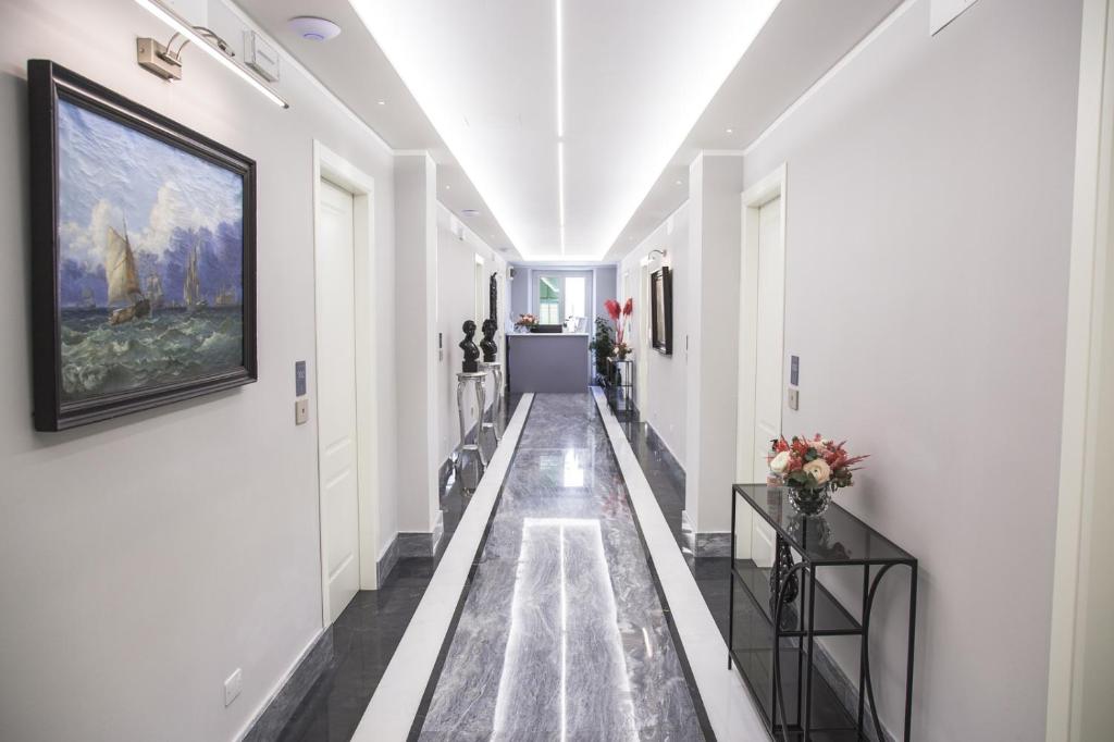 a hallway with white walls and a painting on the wall at Correnti Boutique Hotel in Sanremo