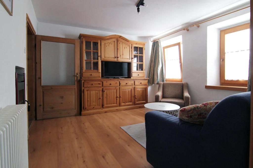 ein Wohnzimmer mit einem Sofa und einem TV in der Unterkunft Appartamenti dolomitici in Padola