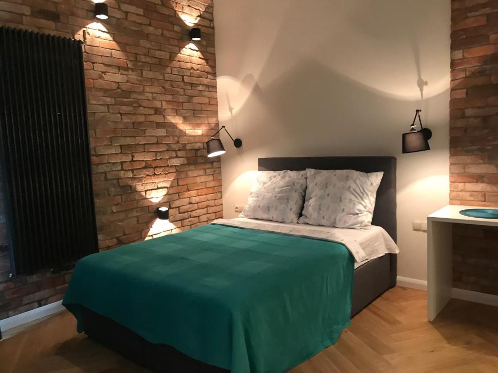 a bedroom with a bed and a brick wall at My Place in Poznan Centrum in Poznań