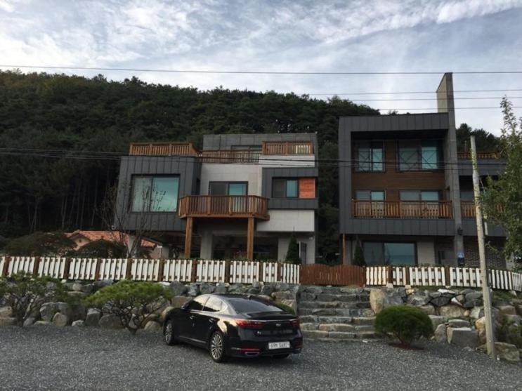 um carro preto estacionado em frente a uma casa em Grace River House Block A em Hoengsong