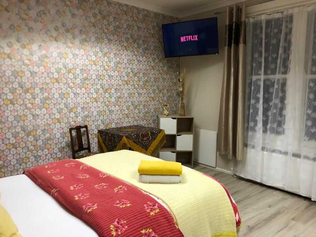 a bedroom with a bed and a tv on the wall at Bright Apartments in Peterborough