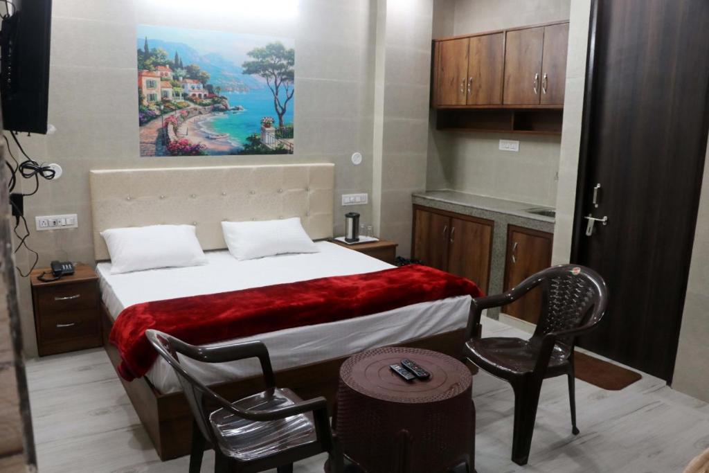 a bedroom with a bed and a chair and a painting at Krishna Dreams in Haridwār