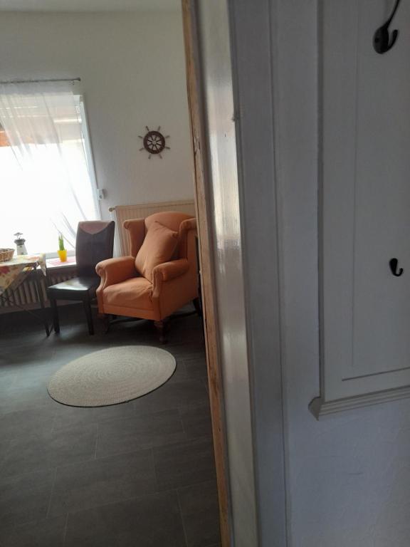 an open door to a living room with an orange chair at Vacanza in Emden