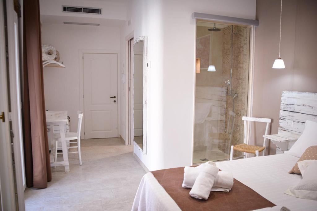 - une chambre blanche avec un lit et un miroir dans l'établissement Torre Pendio b&b, à Corato