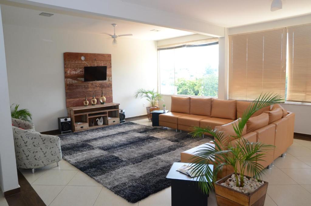 a living room with a couch and a rug at Hotel Canaã Express in Jarinu