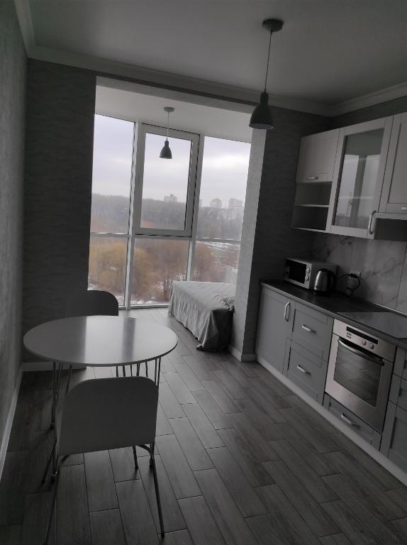 een keuken met een tafel en een bed in een kamer bij Апартаменти Люкс2 in Chmelnytsky