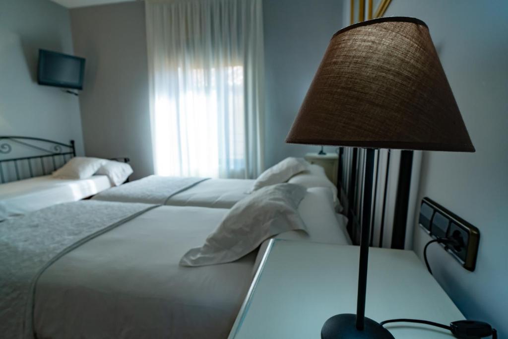 Postel nebo postele na pokoji v ubytování Hotel Alfonso IX
