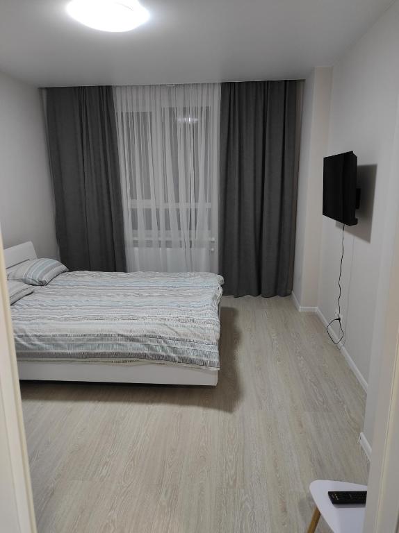 a bedroom with a bed and a television in it at Апартаменти Люкс in Khmelnytskyi