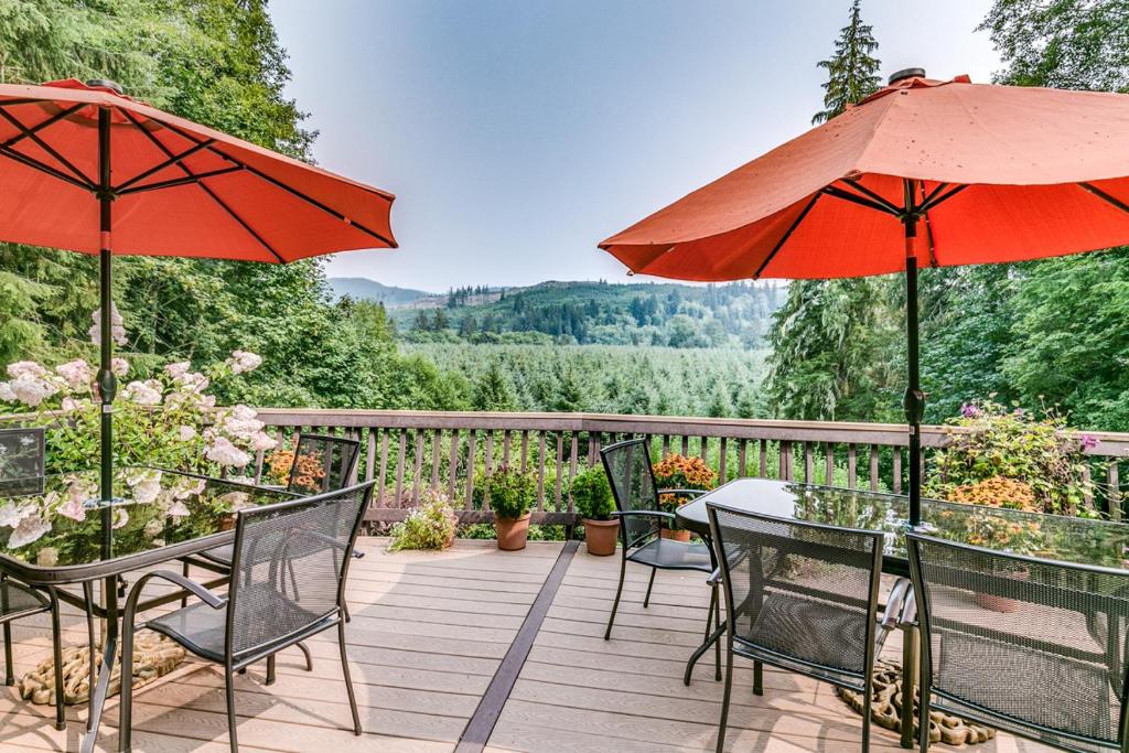a patio with tables and chairs and umbrellas at Misty Valley Inn in Forks