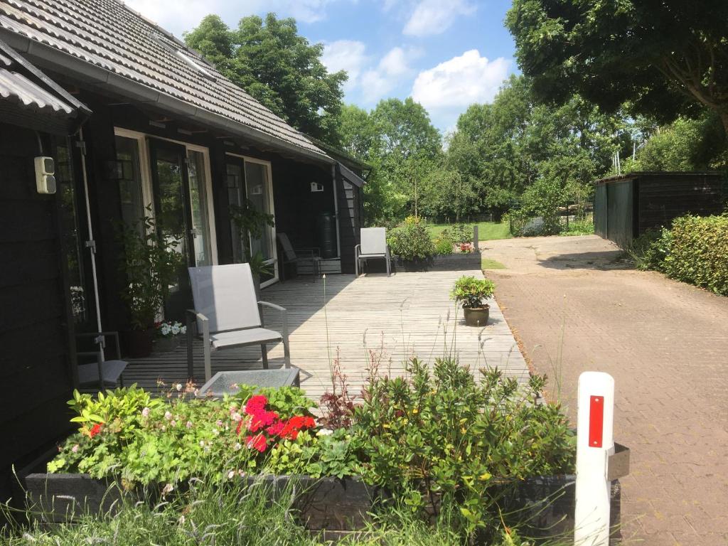 eine Terrasse mit Stühlen und Blumen vor einem Haus in der Unterkunft Klein Vreugderijk in Zwolle