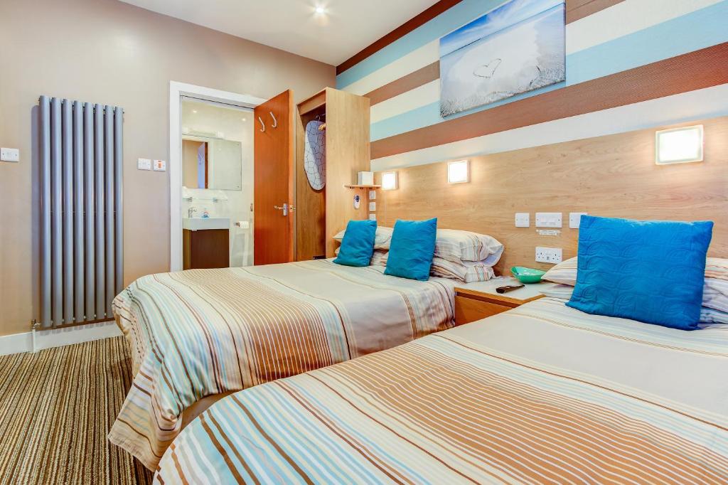 a hotel room with two beds with blue pillows at The Craimar in Blackpool