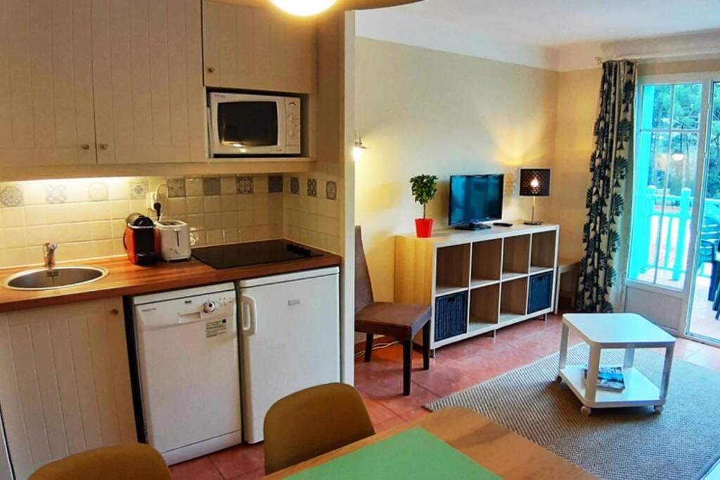 eine kleine Küche mit einem Waschbecken und einem Tisch in der Unterkunft Appartement Lacanau entre Golf et Océan pour 4 personnes in Lacanau