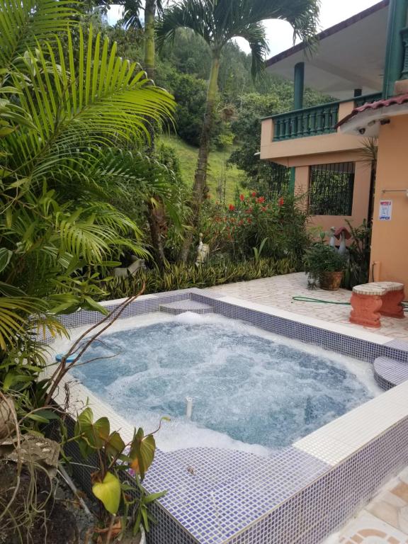 una piscina en un jardín con una casa en Villa Flor, en Los Plátanos
