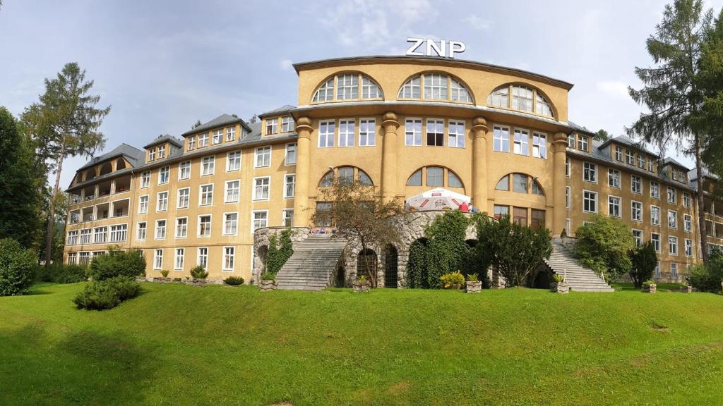 un grande edificio giallo con scale di fronte di Nauczycielskie Centrum a Zakopane