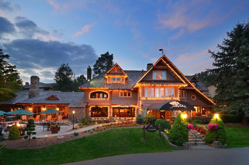 a large wooden house with lights on the yard at Bob Timberlake Inn at Chetola Resort in Blowing Rock