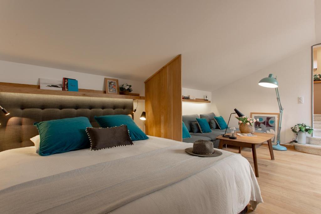 a bedroom with a large bed with blue pillows at Loft Terrasse, l'Hauture, Arles in Arles