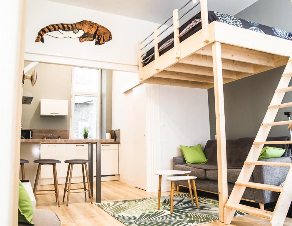 a loft bed with a tiger decal on the wall at La jungle Nantaise in Nantes
