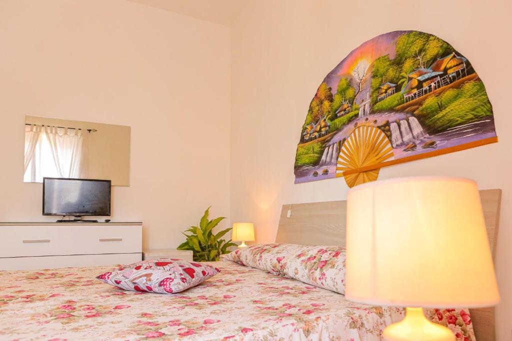 a bedroom with a bed with a lamp and a tv at Mini Hotel Rendez Vous in Ischia