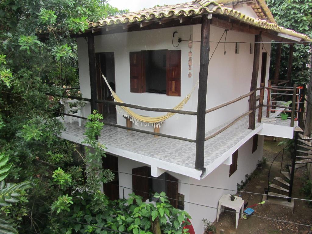 a house with a hammock on the side of it at Casa do Miguel in Itacaré