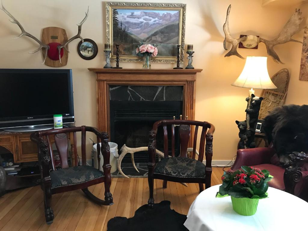 a living room with two chairs and a fireplace at Holiday Lodge Bed and Breakfast in Banff