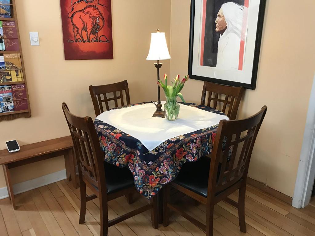a dining room table with a vase of flowers on it at Holiday Lodge Bed and Breakfast in Banff