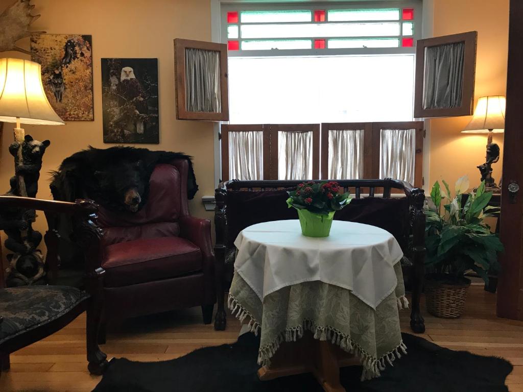 a living room with a table with a vase of flowers on it at Holiday Lodge Bed and Breakfast in Banff