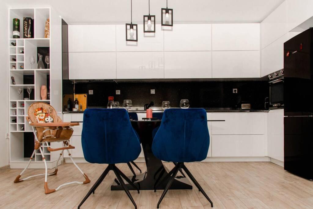 a kitchen with a table and two blue chairs at Super luxurious & spacious designer apartment. in Stara Zagora