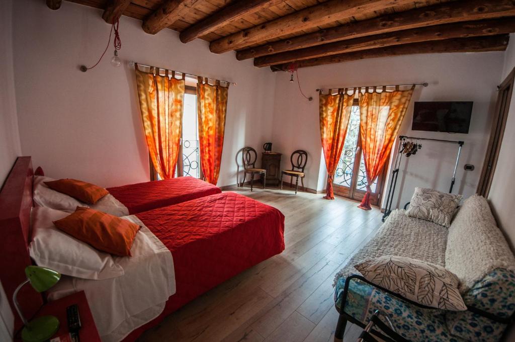 a bedroom with a bed and a couch and windows at B&B Santa Lucia in Bergamo
