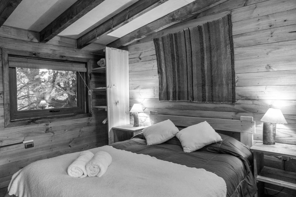 a bedroom with a bed with towels on it at Onai Hostel in Las Trancas
