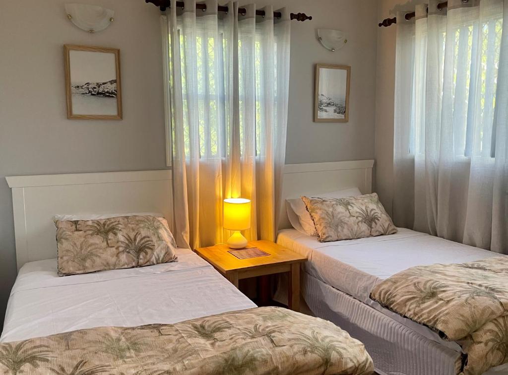 Habitación con 2 camas y una lámpara en una mesa. en Villa Venezia Apt 3 - Spacious Hervey Bay beachfront apartment en Hervey Bay