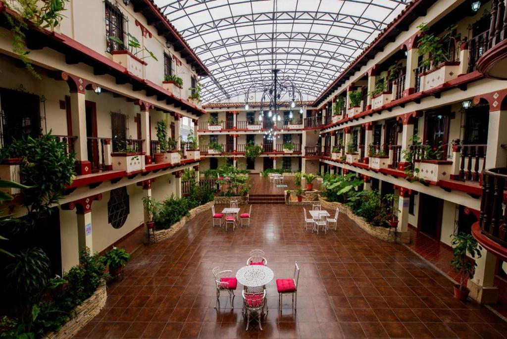 an indoor greenhouse with tables and chairs in a building at Hotel D&rsquo;Monica in San Crist&oacute;bal de Las Casas