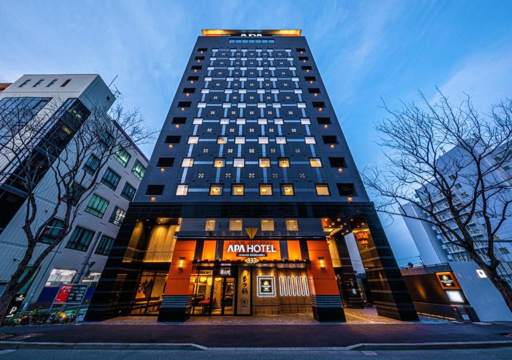 a tall building with a sign on top of it at APA Hotel & Resort Hakata Ekihigashi in Fukuoka