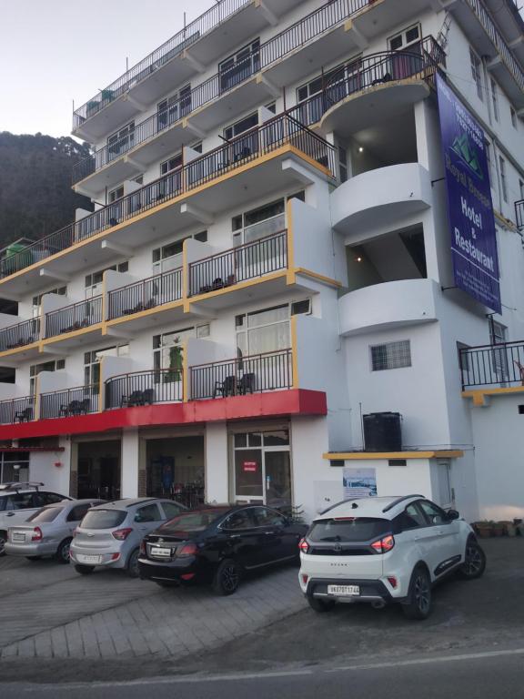 a large white building with cars parked in a parking lot at ROYAL BREEZE HOTEL & RESTAURANT Received Most Rated Traveller Award Property For Year 2023-2024 !! in Mussoorie