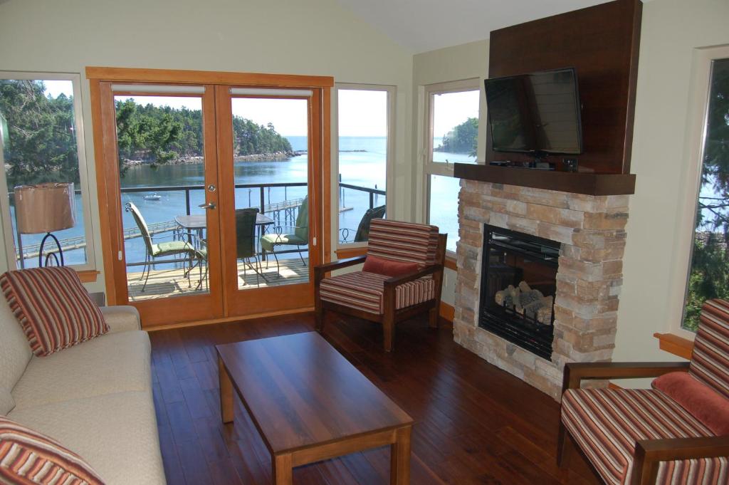 sala de estar con chimenea y TV en Mayne Island Resort en Mayne Island