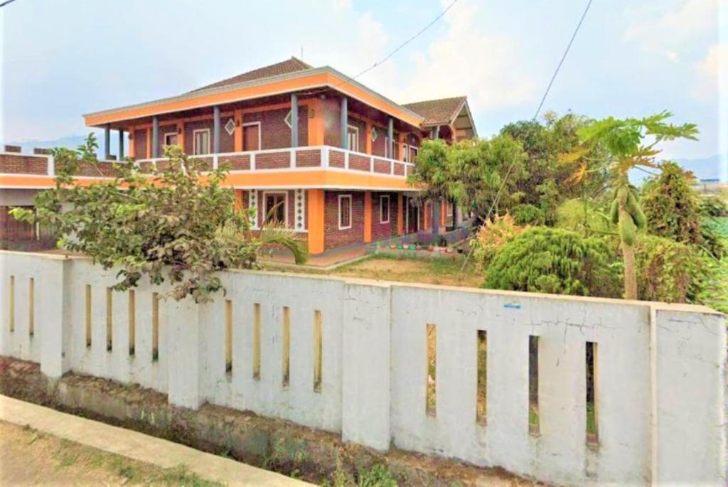 uma casa atrás de uma parede de concreto em frente em Villa Orange Lembang Pengkolan em Lembang